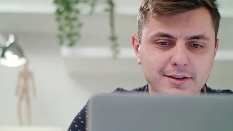 A Young Man Using a Laptop Indoors Stock Footage 83830707