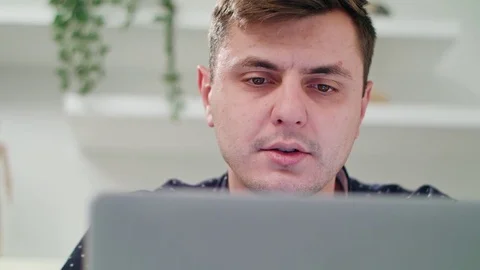 A Young Man Using a Laptop Indoors Stock Footage 83831102