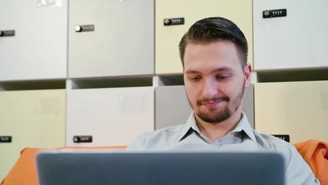 A Young Man Using a Laptop Indoors Stock Footage 84770908