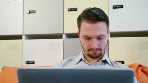 A Young Man Using a Laptop Indoors Stock Footage 84771225