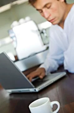 Young man using laptop in kitchen Stock Photos