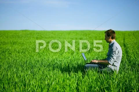 Young man using a laptop outdoors Stock Photos