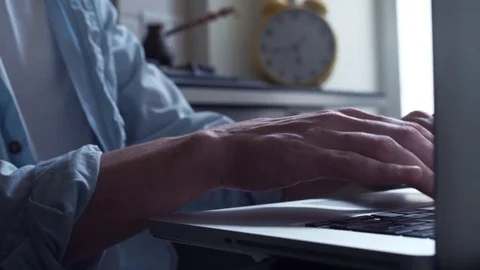 Young man using laptop pouring steaming coffee into a cupat kitchen. Stock Footage 82933139
