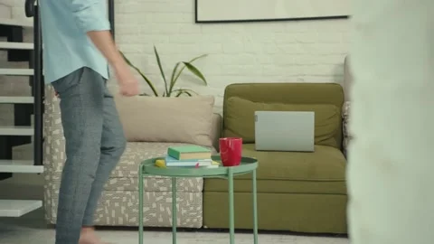 Young man using laptop sitting on couch in modern living room at home internet Stock Footage 132539474