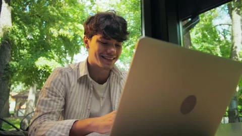 Young man using laptop sitting in restaurant.Businessman Works remotely in t Stock Footage 202479723