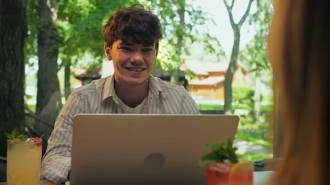Young man using laptop sitting in restaurant.Businessman Works remotely in t Stock Footage 202480140