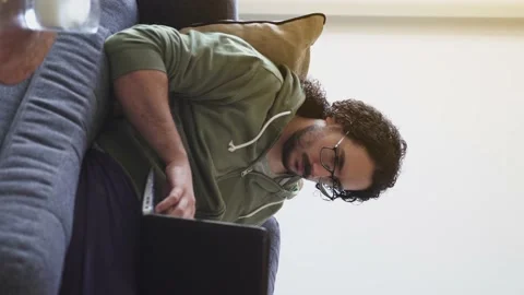 Young man using laptop on the sofa Stock Footage 164906182