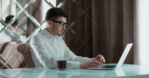 Young man using laptop studying online working from home in internet, smiling Stock Footage 121567503