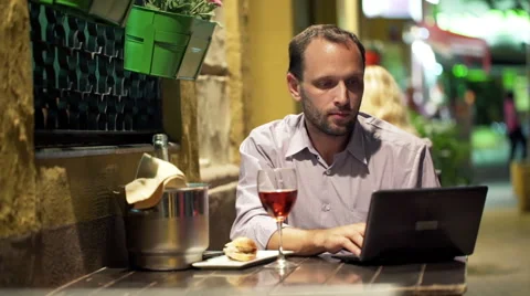 Young man using laptop while sitting in cafe at night HD 스톡 동영상 46977112