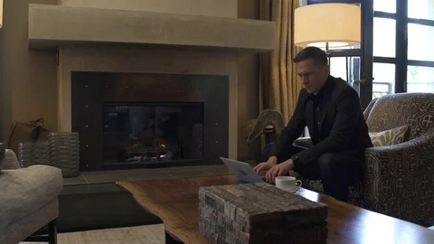 Young man using a laptop while sitting in a suite Stock Footage 83392519