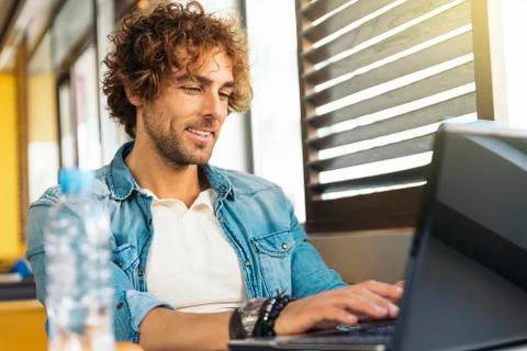 Young man using laptop while to have lunch. Stock Photos