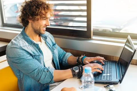 Young man using laptop while to have lunch. Stock Photos