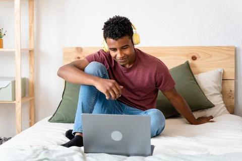 Young man using laptop while watching movies. Stock Photos