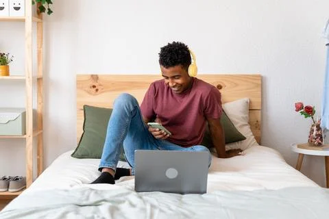 Young man using laptop while watching movies. Stock Photos