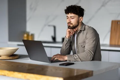 Young man using laptop writing email or message, chatting, working online, .. Foto stock