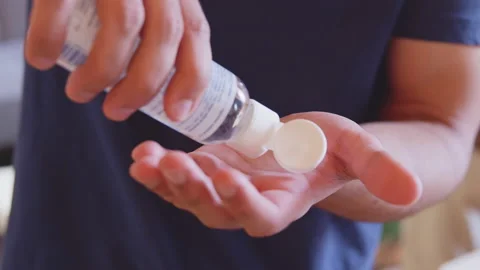 Young man using liquid hand sanitizer during quarantine. People using alcohol Stock Footage 135073186