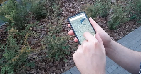 Young man using a map in a smartphone outdoors, modern technology concept 動画素材 126222277