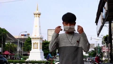 Young man using a mask at street tugu Yogyakarta Stock Footage 167333589