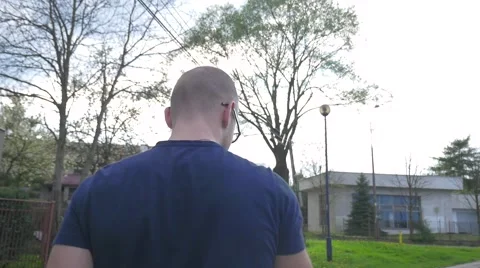 Young man using mobile phone. He is sitting on the bench. Later he is walking. Stock Footage 62520837