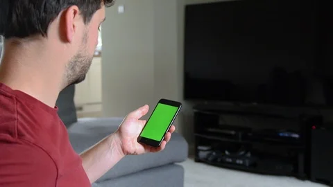 Young man using mobile phone with green screen Stock Footage 92284835