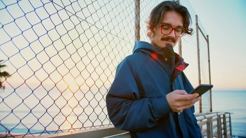 Young man using mobile phone or smartphone app checking feed to be up to date Video stock 100861722