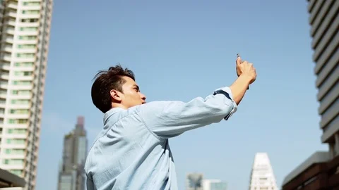 A Young Man Using Mobile Phone in Urban City. Low Angle View. Slow Motion. Mo Stock Footage 122722371