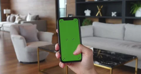 Young man using Mobile Phone with Green Screen in Vertical Mode at home. Male Stock Footage 249457792
