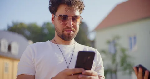 Young man using mobile phone in park Video stock 252536627