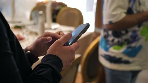 Young man using a mobile phone, viewing news on the Internet on a smartphone Stock Footage 273913577