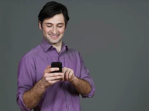 Young man using mobile phone, smiling Stock Photos