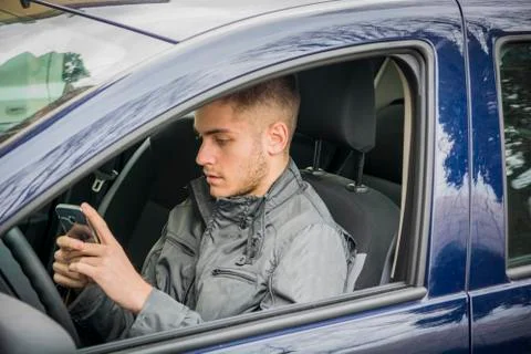 Young Man using mobile phone while driving Stock Photos