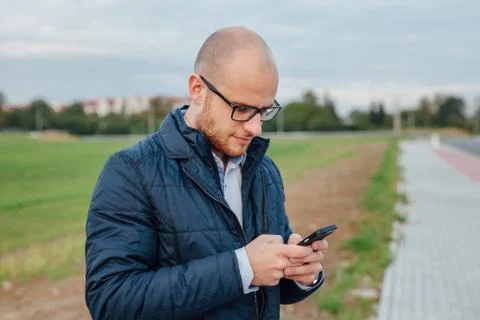 Young man is using mobile phone. Outdoor background Stock Photos