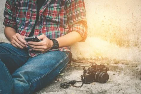 Young Man Using Mobile Phone with old retro camera Stock Photos