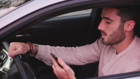 Young Man using mobile phone sitting in car Stock Photos