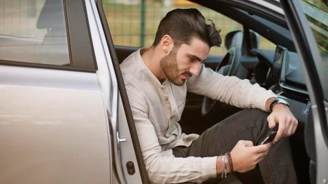 Young Man using mobile phone sitting in car Stock Photos