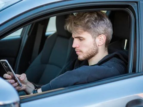 Young Man using mobile phone while driving Stock Photos