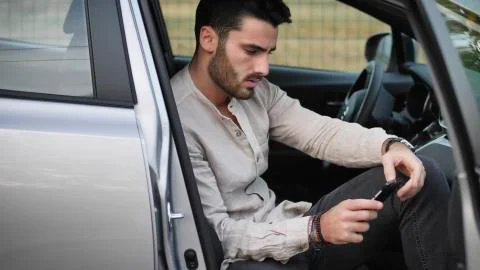 Young Man using mobile phone sitting in car Stock Photos
