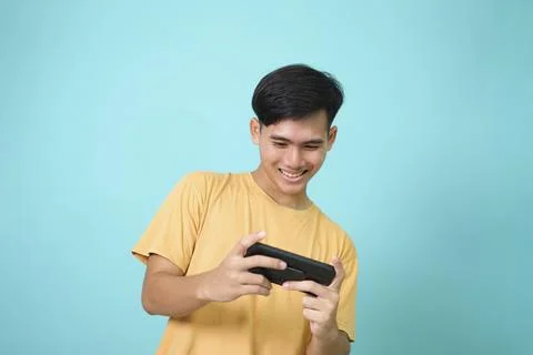Young man using mobile phone playing online game Stock Photos