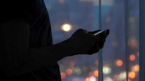 Young man using mobile smartphone indoor  in the background of a window 스톡 동영상 83038422