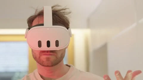 Young man using a modern virtual reality headset to interact with a digital 스톡 동영상 335201058
