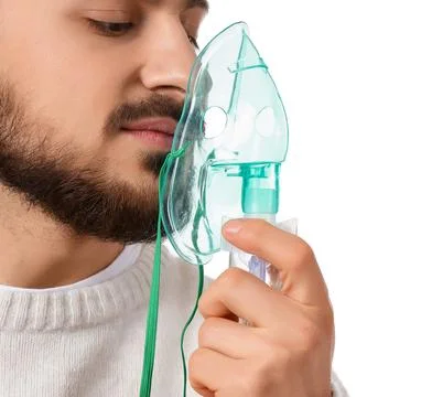Young man using nebulizer on white background, closeup Stock Photos