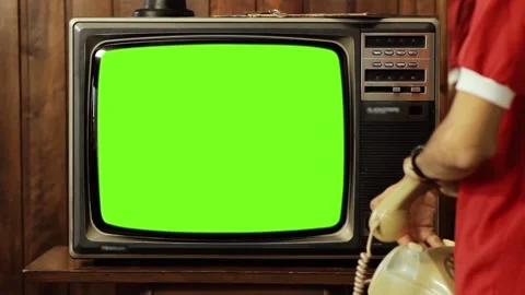 Young Man using an Old Phone While Turning On and Off Retro TV Green Screen. Stock Footage
