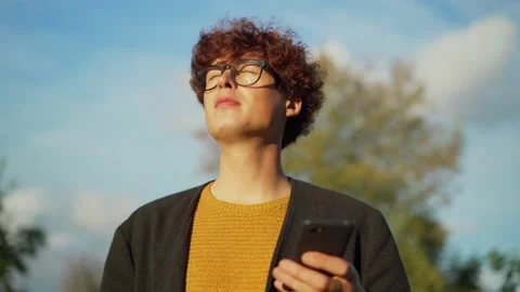 Young man using phone and enjoying sunny day Stock Footage 139506524