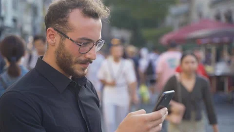 Young man using phone in crowd. 库存影片 213514840