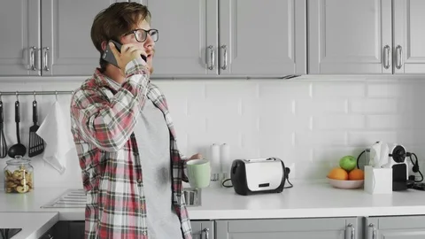 Young man using phone in the kitchen Video stock 125128922