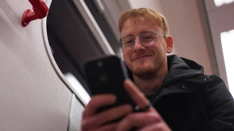 Young man using phone on metro train Stock Footage 342046765