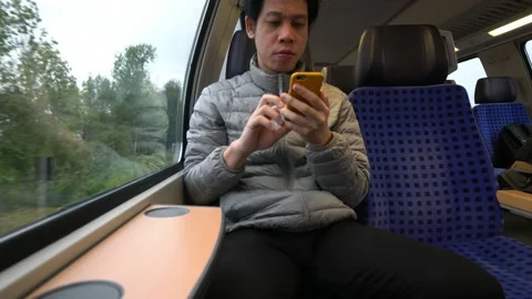 Young Man Using Phone on Train Journey Stock Footage 314611661