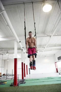 Young Man Using Resistance Bands In Gym 写真素材