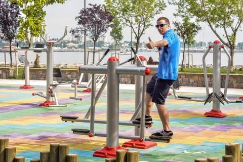 Young man is using running equipment in the park with a sea background. Foto stock