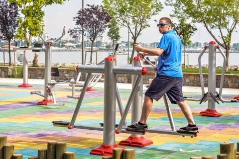 Young man is using running equipment in the park with a sea background. Foto stock